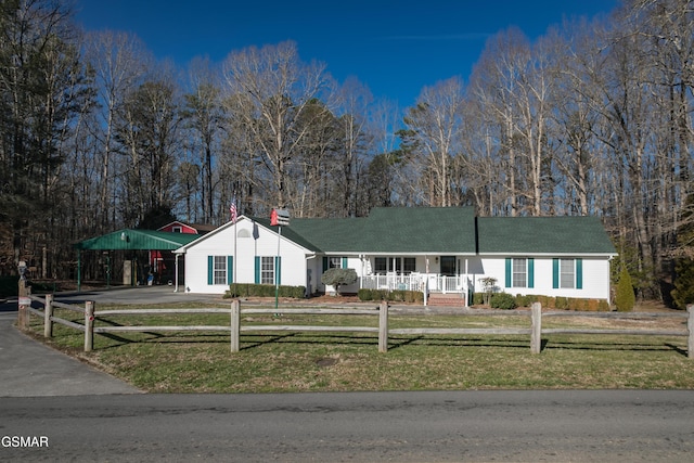 ranch-style home with driveway, a fenced front yard, and a front lawn