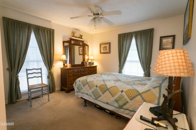 carpeted bedroom with ceiling fan and multiple windows