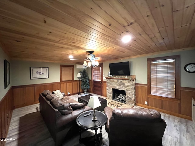 222 Poplar Ln, Gatlinburg, TN 37738 - living room with wainscoting, wood finished floors, wood ceiling, a stone fireplace, and ceiling fan