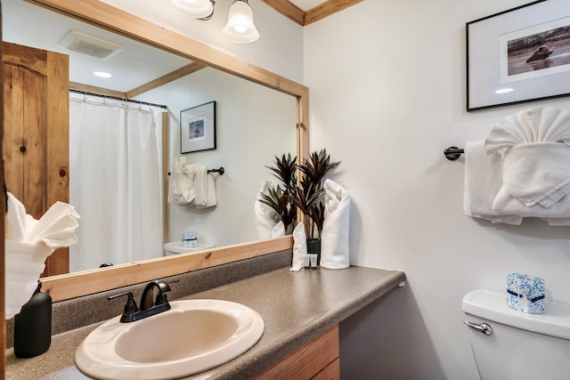 bathroom featuring ornamental molding, visible vents, vanity, and toilet