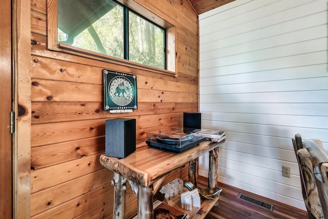 home office with wood walls, wood finished floors, and visible vents