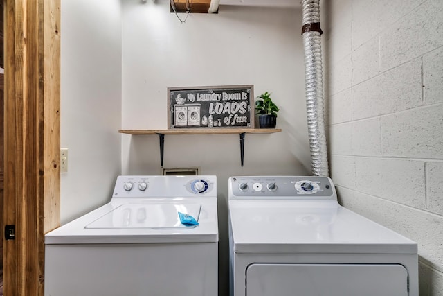 laundry room with washer and dryer, laundry area, and concrete block wall