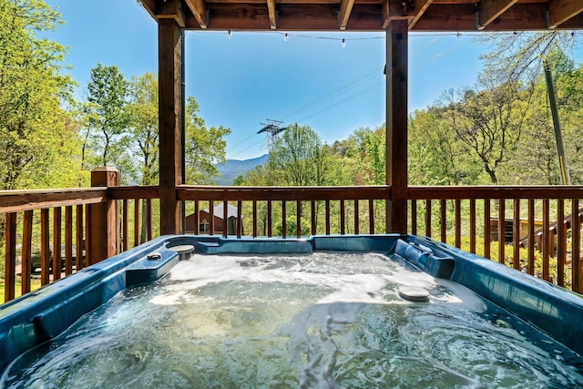 wooden deck featuring a hot tub