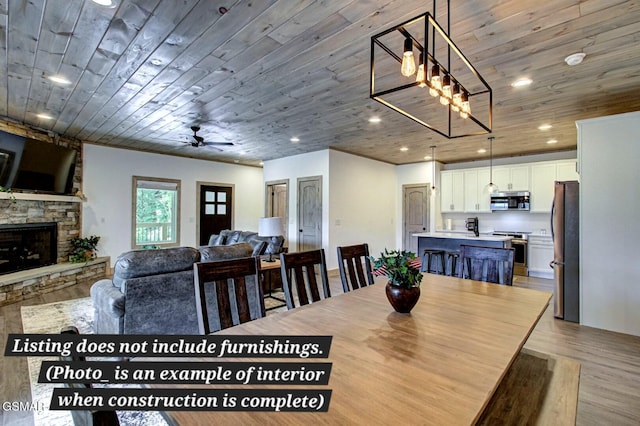 dining room featuring wooden ceiling, a fireplace, light wood-style flooring, and recessed lighting