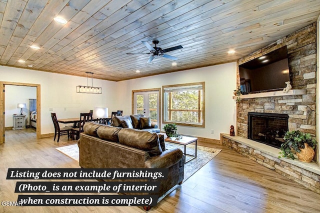 living area featuring wood ceiling, light wood-style flooring, a ceiling fan, and a stone fireplace