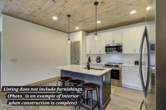 kitchen with a center island with sink, appliances with stainless steel finishes, white cabinets, and light countertops