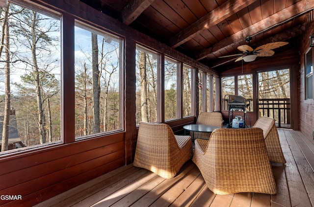 sunroom with ceiling fan, lofted ceiling with beams, and wooden ceiling