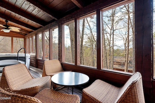 sunroom / solarium with lofted ceiling with beams, plenty of natural light, wood ceiling, and a ceiling fan