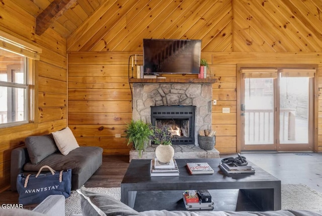 living room featuring wooden ceiling, wood finished floors, vaulted ceiling, a stone fireplace, and wood walls