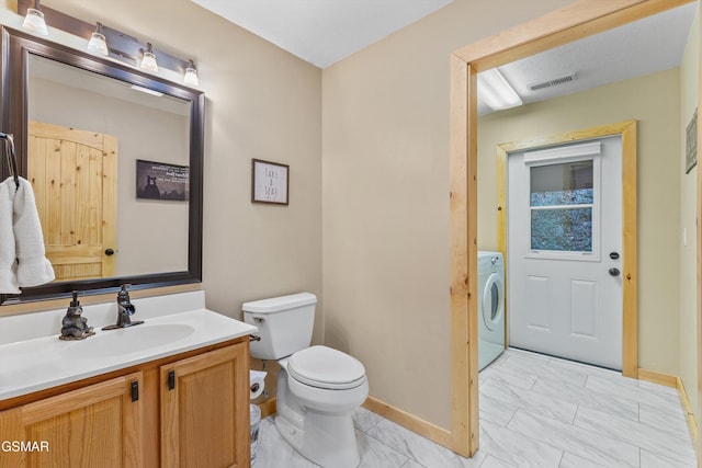 bathroom featuring visible vents, baseboards, toilet, washer / clothes dryer, and vanity