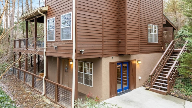 view of property exterior featuring a patio, stairway, and stucco siding