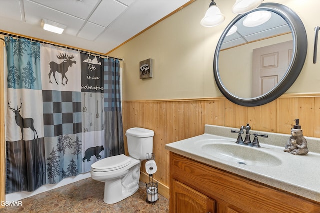 bathroom with a shower with shower curtain, toilet, wainscoting, wood walls, and vanity