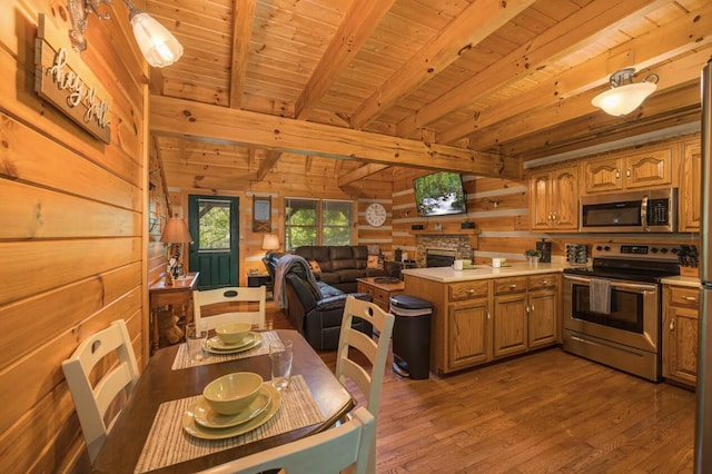 kitchen featuring beamed ceiling, wood walls, wood ceiling, and stainless steel appliances