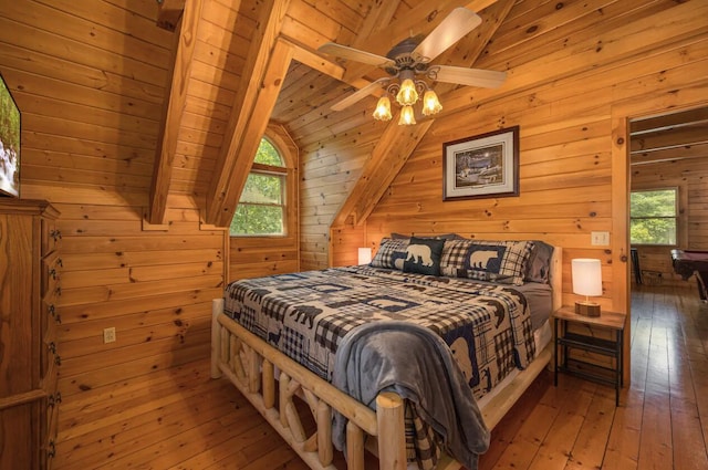 bedroom with vaulted ceiling with beams, wood walls, wood ceiling, and ceiling fan