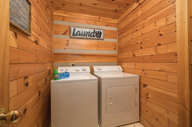 washroom with washing machine and dryer, wood walls, and wooden ceiling