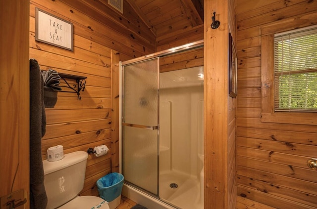 bathroom featuring wood walls, a shower with shower door, vaulted ceiling, and toilet