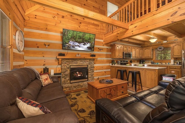 living room featuring a stone fireplace, wooden walls, beamed ceiling, and wooden ceiling