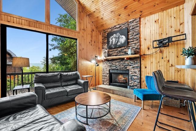 2295 Bluff Mountain Rd, Sevierville, TN 37876 - living room with wooden walls, high vaulted ceiling, a stone fireplace, wood finished floors, and wooden ceiling