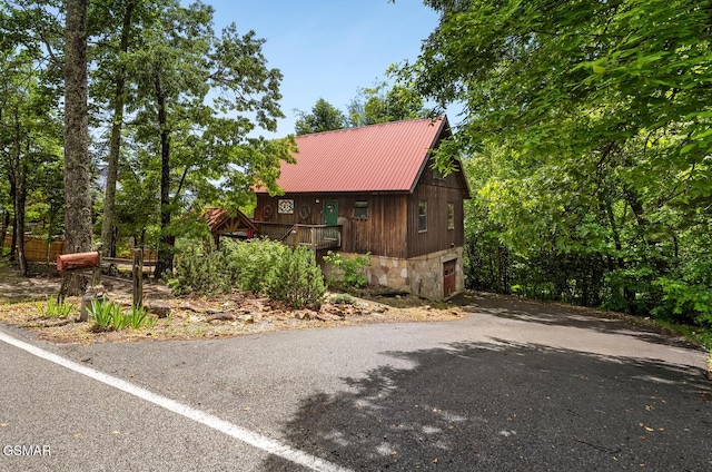 2295 Bluff Mountain Rd, Sevierville, TN 37876 - rustic home with a garage, metal roof, driveway, and stone siding