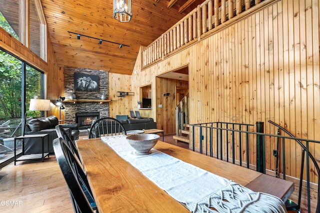 2295 Bluff Mountain Rd, Sevierville, TN 37876 - dining space with high vaulted ceiling, a fireplace, wood finished floors, wooden walls, and wood ceiling