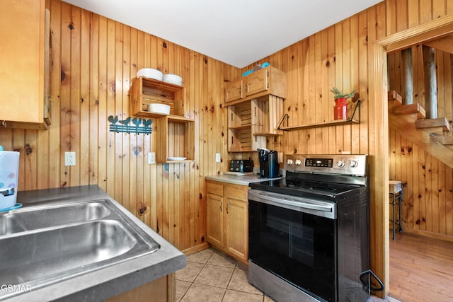 2295 Bluff Mountain Rd, Sevierville, TN 37876 - kitchen featuring stainless steel electric range, a sink, wood walls, baseboards, and brown cabinets