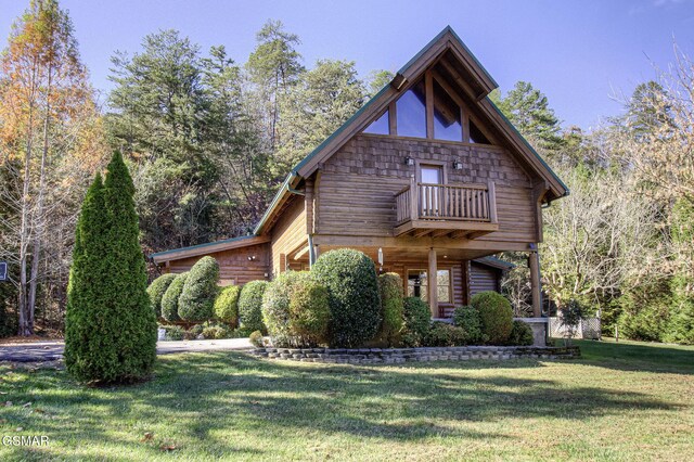 view of front of house with a balcony and a front lawn