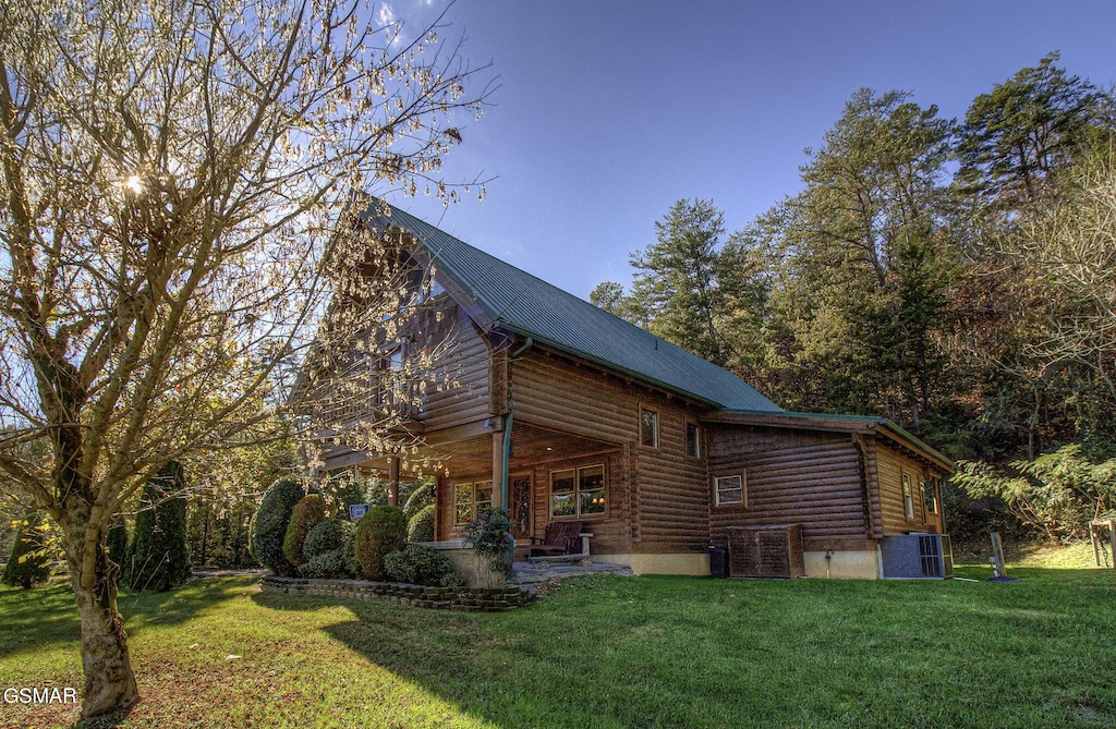 view of side of home with a yard and central air condition unit