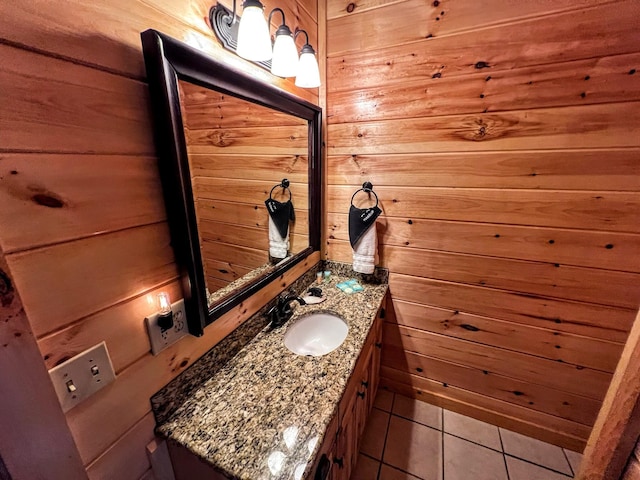 bathroom with wood walls, tile patterned flooring, and vanity