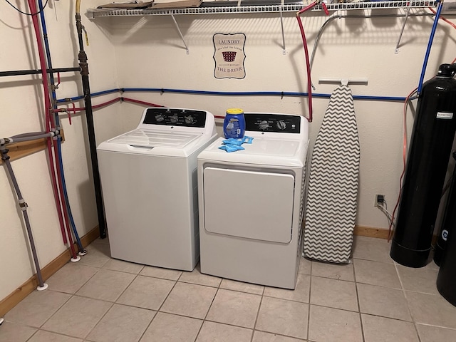 laundry area featuring light tile patterned flooring and washing machine and clothes dryer