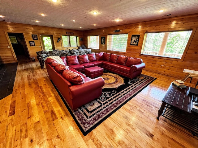 living room with hardwood / wood-style flooring and wood walls