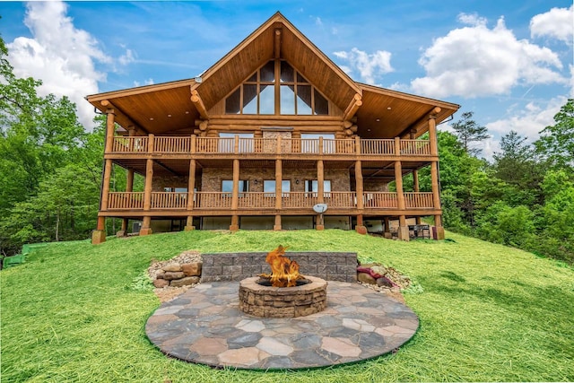 back of house featuring a yard and an outdoor fire pit