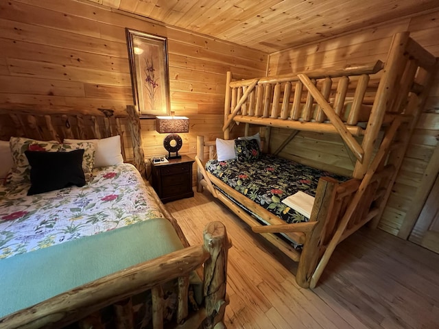 bedroom featuring wooden walls, wooden ceiling, and light hardwood / wood-style floors