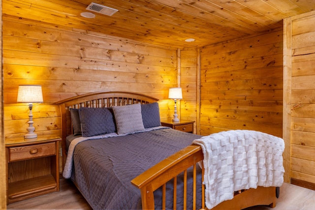 bedroom with wood walls, light hardwood / wood-style floors, and wood ceiling