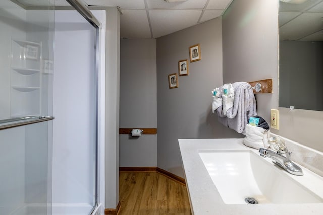 bathroom featuring a shower with door, a drop ceiling, and wood-type flooring