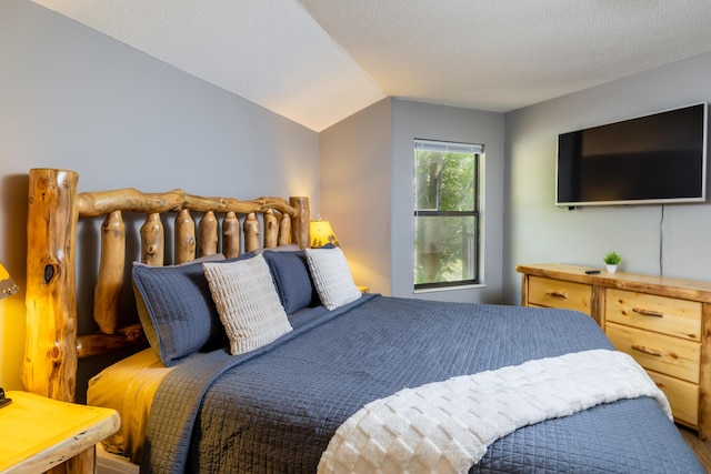 bedroom featuring a textured ceiling and lofted ceiling