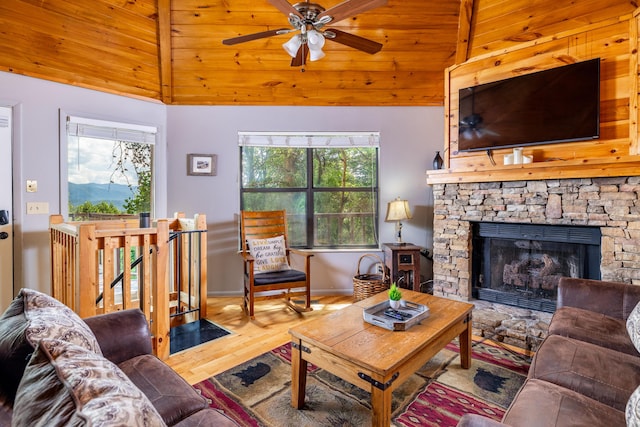 living room featuring ceiling fan, wooden ceiling, a stone fireplace, high vaulted ceiling, and hardwood / wood-style floors