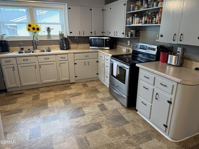 211 Valley Dr, Pigeon Forge, TN 37863 - kitchen with stainless steel appliances, light countertops, white cabinetry, and stone finish floors