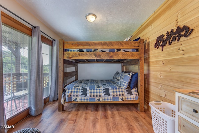 1315 Mccarter Hollow Rd, Sevierville, TN 37862 - bedroom with wood finished floors, a textured ceiling, and wood walls
