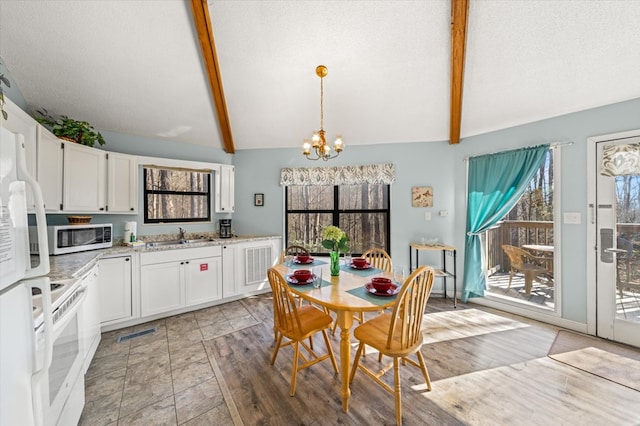 interior space with a notable chandelier, white appliances, white cabinets, lofted ceiling with beams, and decorative light fixtures