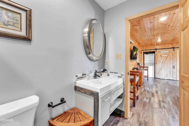 half bathroom with vanity, recessed lighting, toilet, wood ceiling, and wood finished floors