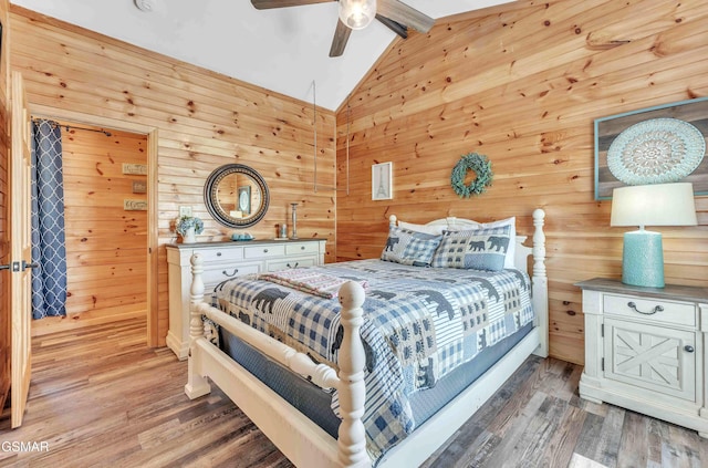 bedroom with ceiling fan, light wood-style floors, wooden walls, and lofted ceiling with beams