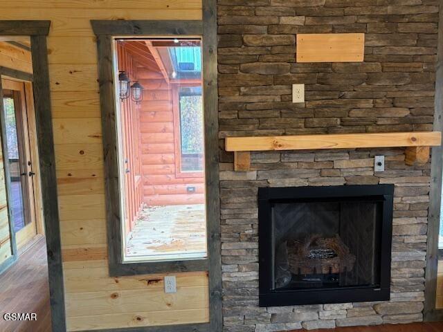 details featuring a stone fireplace and wood walls