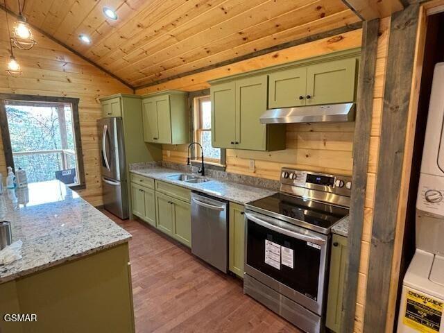 kitchen with appliances with stainless steel finishes, green cabinetry, lofted ceiling, and sink