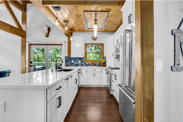 2517 Angler Way, Sevierville, TN 37876 - kitchen featuring appliances with stainless steel finishes, a peninsula, a wood ceiling with exposed beams, healthy amount of natural light, and decorative backsplash