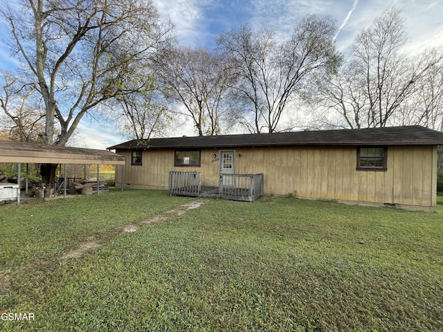 rear view of house with a carport and a lawn