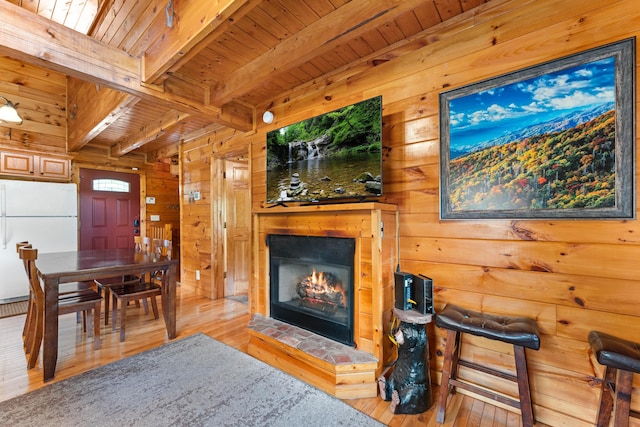 living room featuring wood ceiling, hardwood / wood-style floors, wood walls, and beam ceiling