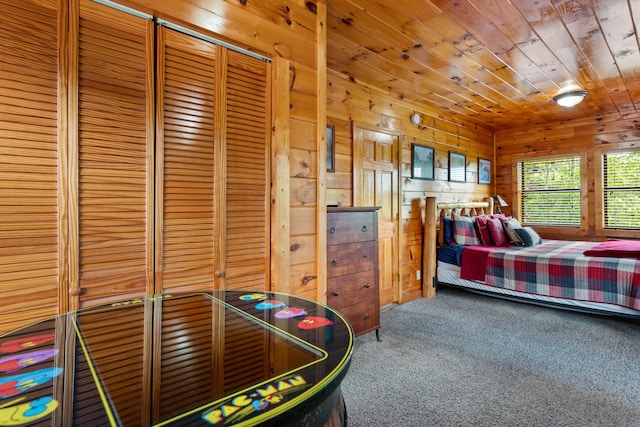 carpeted bedroom featuring wood ceiling, wooden walls, and a closet