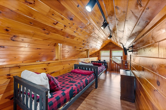 bedroom with lofted ceiling, wood finished floors, wood ceiling, and wooden walls