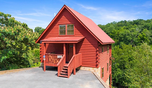 view of front facade featuring metal roof and log siding