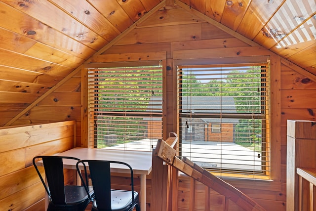 dining space with vaulted ceiling, wood ceiling, and wood walls